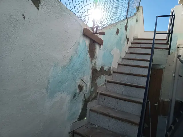 Muro de escalera con las zonas dañadas reparadas con mortero