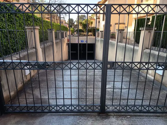 Puerta de garaje y barandillas de una comunidad de vecinos pintadas en gris oscuro