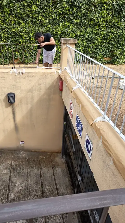 Pintor de Pinturas Medrano pintando una barandilla en una comunidad de vecinos de Mallorca